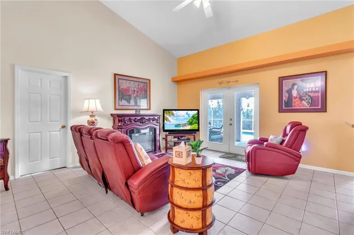 Living area featuring french doors, high vaulted ceiling, light tile patterned floors, and a ceiling fan