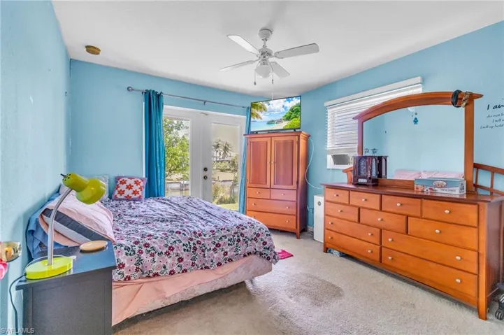 Bedroom with ceiling fan, carpet floors, french doors, and access to exterior
