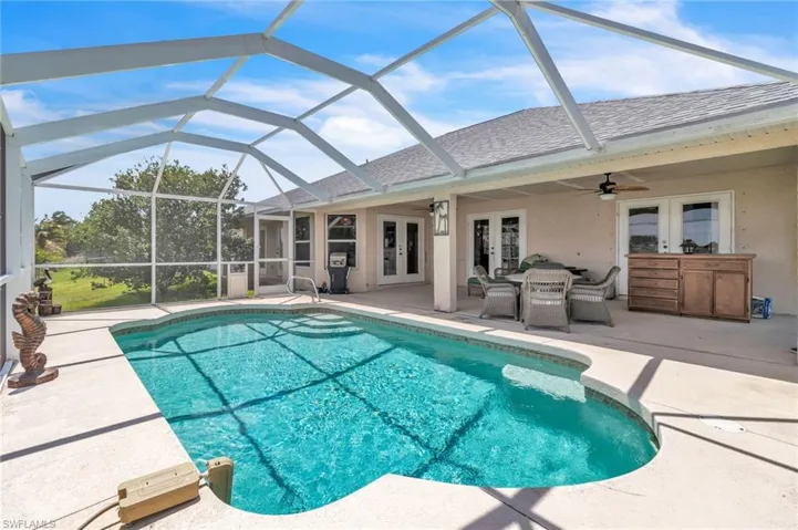 Outdoor pool featuring a lanai, a ceiling fan, a patio, and french doors