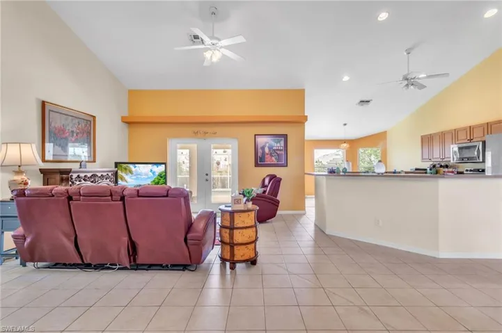 Living area featuring visible vents, high vaulted ceiling, ceiling fan, and light tile patterned flooring