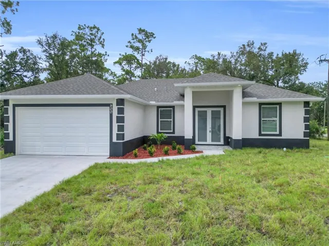 View of front of house featuring stucco siding, roof with shingles, a front lawn, and a garage