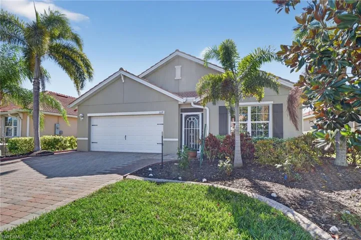 View of front of house featuring stucco siding, decorative driveway, a tiled roof, and an attached garage