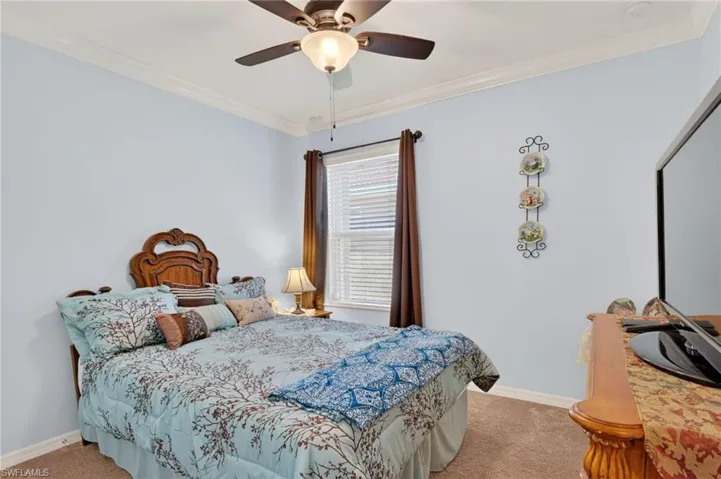 Bedroom featuring ornamental molding, carpet floors, and ceiling fan