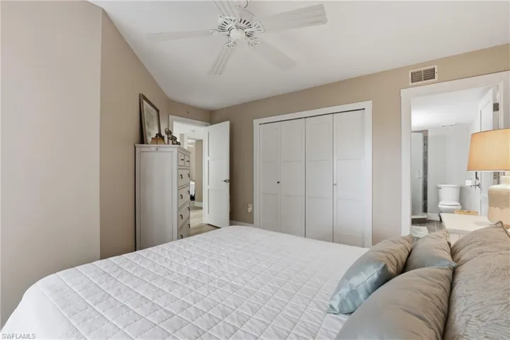 Bedroom with a ceiling fan, a closet, and ensuite bath