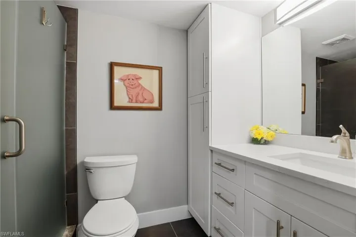 Full bathroom featuring vanity, a stall shower, and dark tile patterned flooring