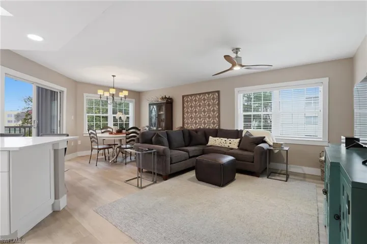 Living room featuring light wood-type flooring, a ceiling fan, and hanging lights