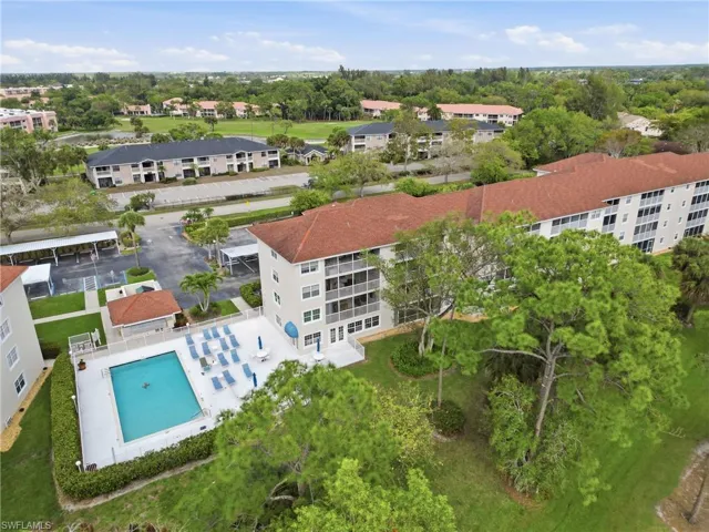 Drone / aerial view of apartment complex and a pool
