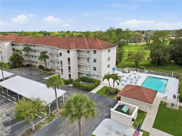 Drone / aerial view of a pool and apartment complex / building