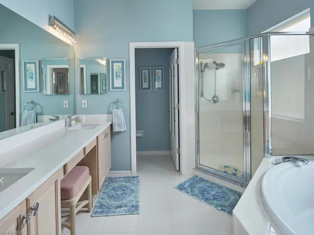 En suite primary bath with dual sinks, walk-in shower & soaking tub.