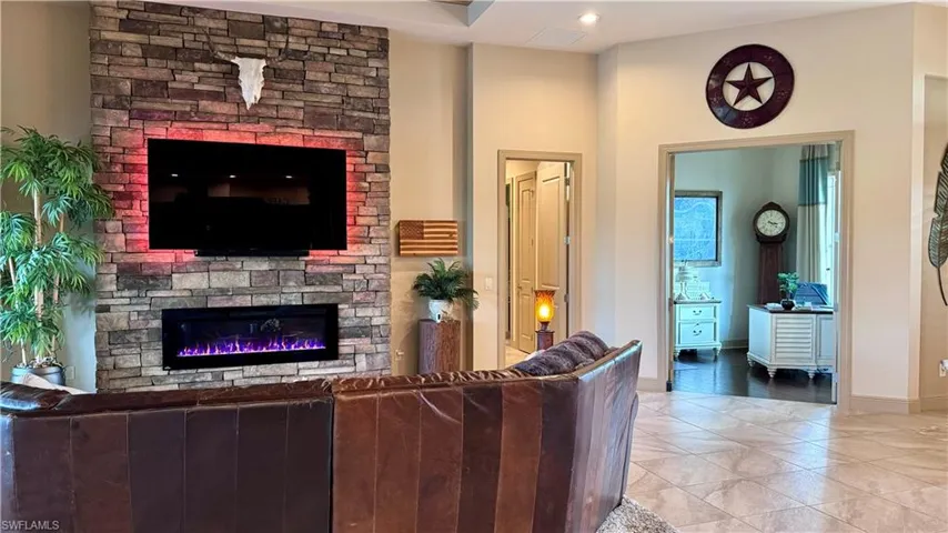 Tiled living room featuring a stone fireplace