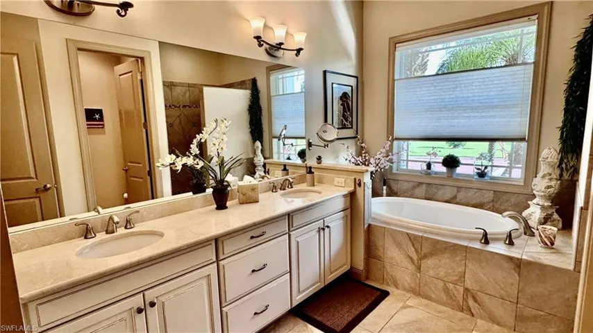 Bathroom featuring separate shower and tub, tile patterned flooring, and vanity
