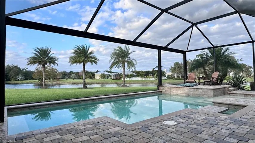 View of pool with a lanai, a lawn, a water view, and a patio