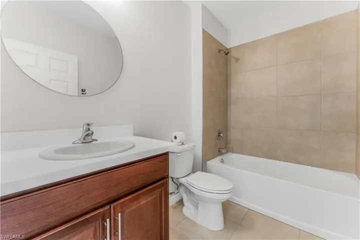 Bathroom with vanity, tile patterned floors, and tub / shower combination
