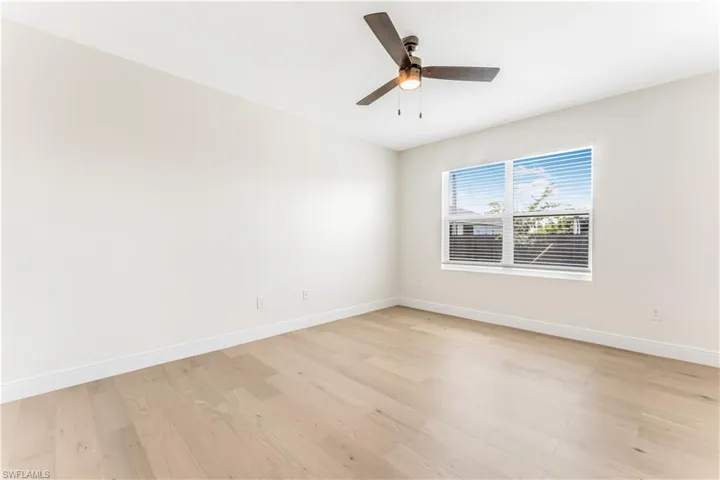 Empty room featuring light wood-style flooring and a ceiling fan