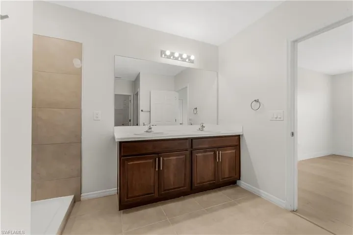 Bathroom featuring double vanity and tile patterned flooring