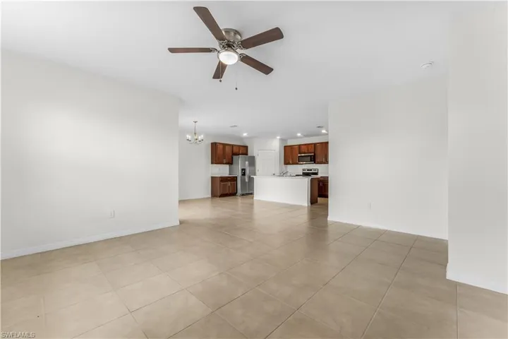 Unfurnished living room with ceiling fan, recessed lighting, a chandelier, and light tile patterned floors