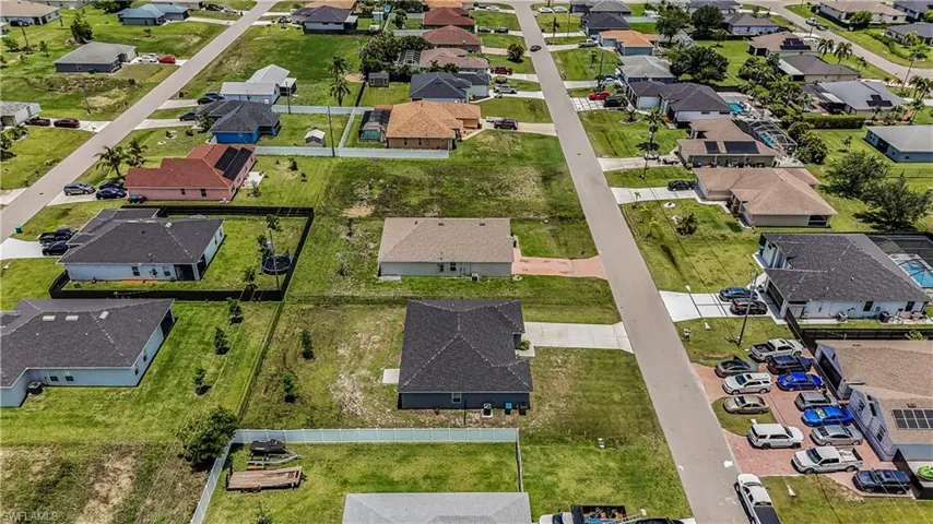 Aerial view of property and surrounding area with nearby suburban area
