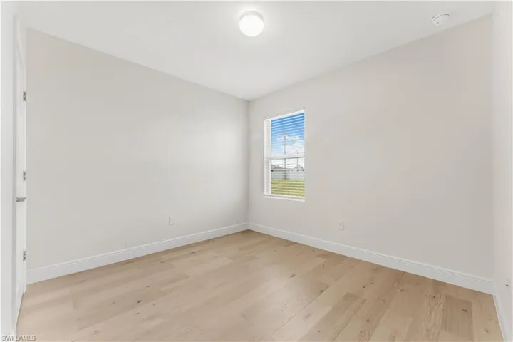 Spare room featuring light wood-style flooring and a smoke detector
