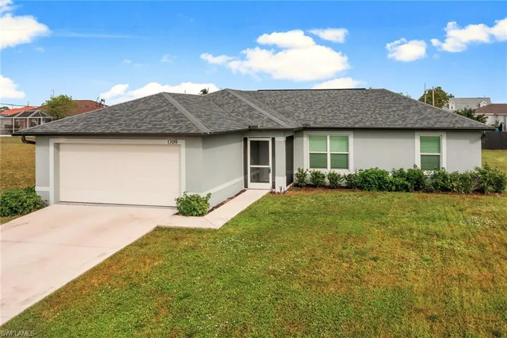 Ranch-style home with a garage and a front yard