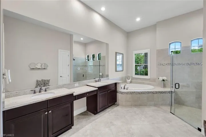 Primary Bathroom with double vanities, soaking tub and makeup vanity area.  Private water closet and plantation shutter.