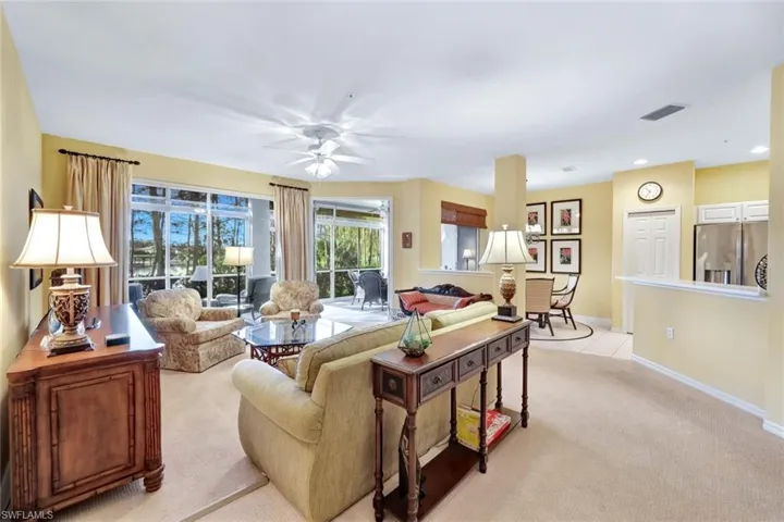 Carpeted living room with ceiling fan
