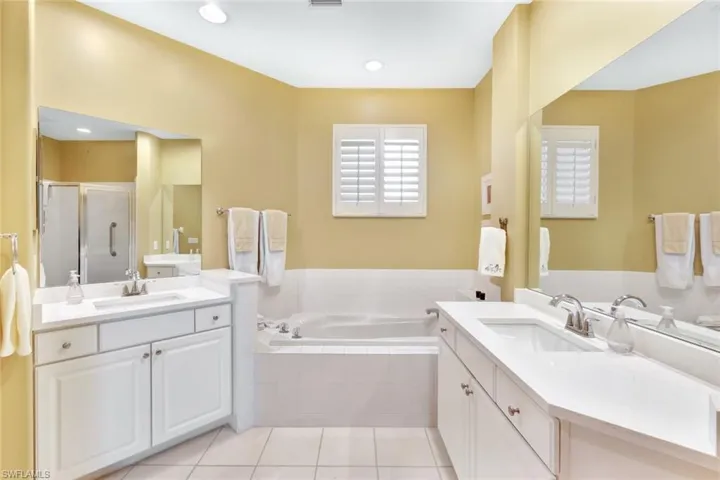 Bathroom with vanity, tile patterned floors, and independent shower and bath