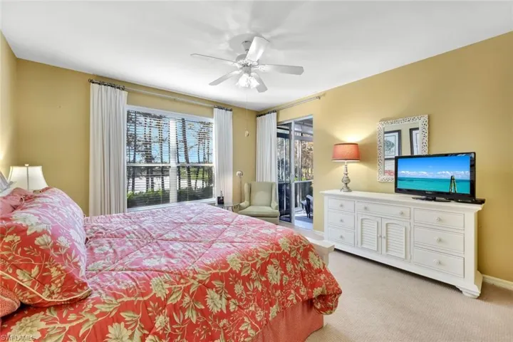 Carpeted bedroom featuring access to exterior and ceiling fan