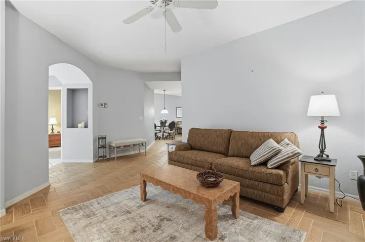 Living area featuring a ceiling fan and arched walkways