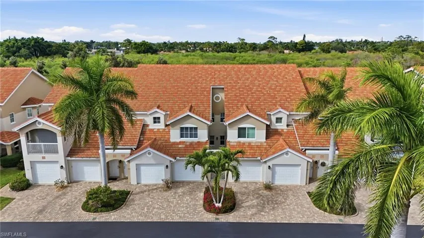 View of front facade with driveway, stucco siding, a garage, and a tiled roof