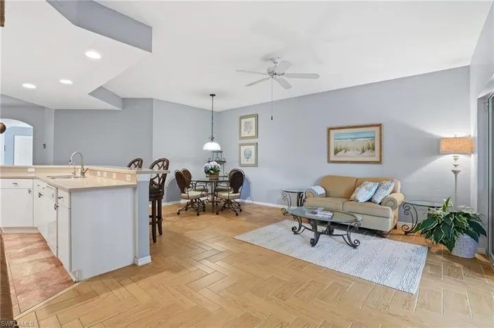 Living room featuring arched walkways, a ceiling fan, and recessed lighting