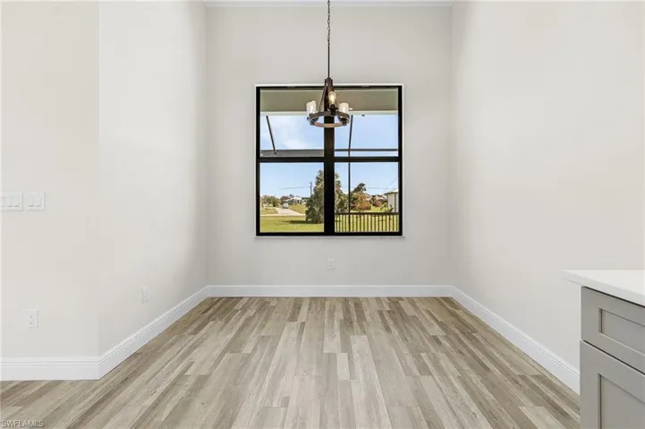 Unfurnished dining area featuring an inviting chandelier and light hardwood / wood-style floors