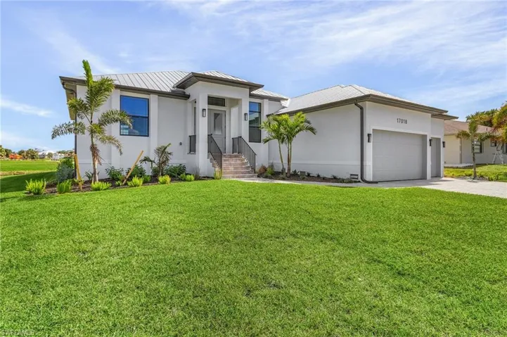 View of front of property with a front lawn and a garage