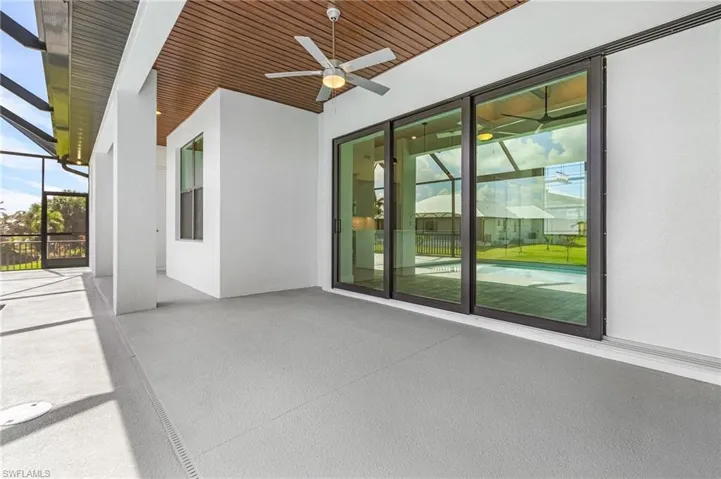 View of patio / terrace featuring glass enclosure and ceiling fan