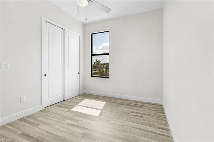 Unfurnished bedroom featuring a closet, light wood-type flooring, and ceiling fan