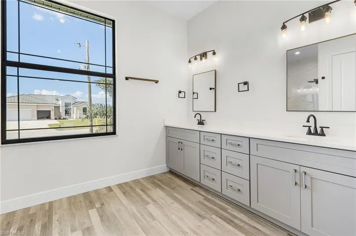 Bathroom featuring vanity, a shower, and wood-type flooring