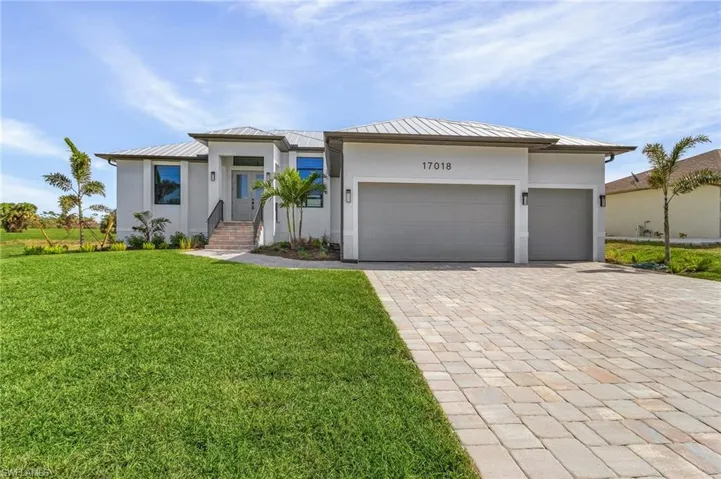 View of front of house featuring a front yard and a garage