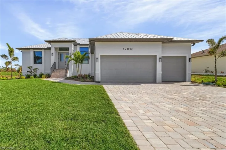 View of front of property featuring a front yard and a garage