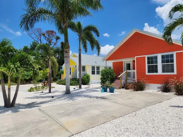 Vibrantly painted exterior featuring a covered porch, white window trim, and a shingle-style facade