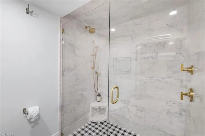 Bathroom with a marble finish shower