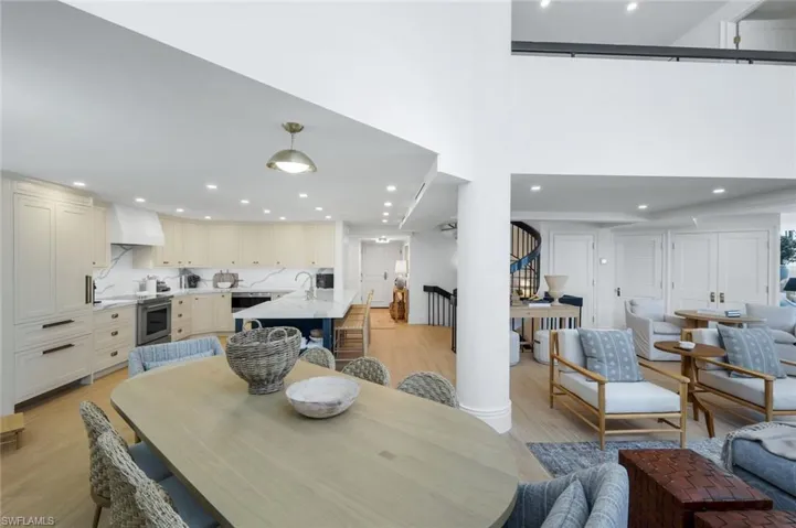 Dining room featuring light wood finished floors, recessed lighting, and a high ceiling
