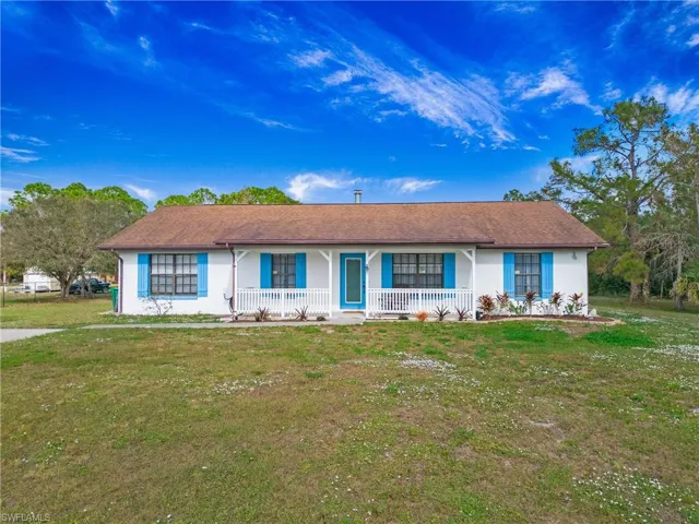 Ranch-style home featuring covered porch and front yard