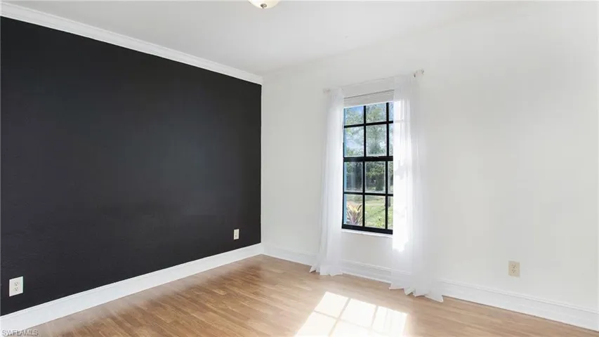 Bedroom 3 featuring light colored laminate flooring and crown molding