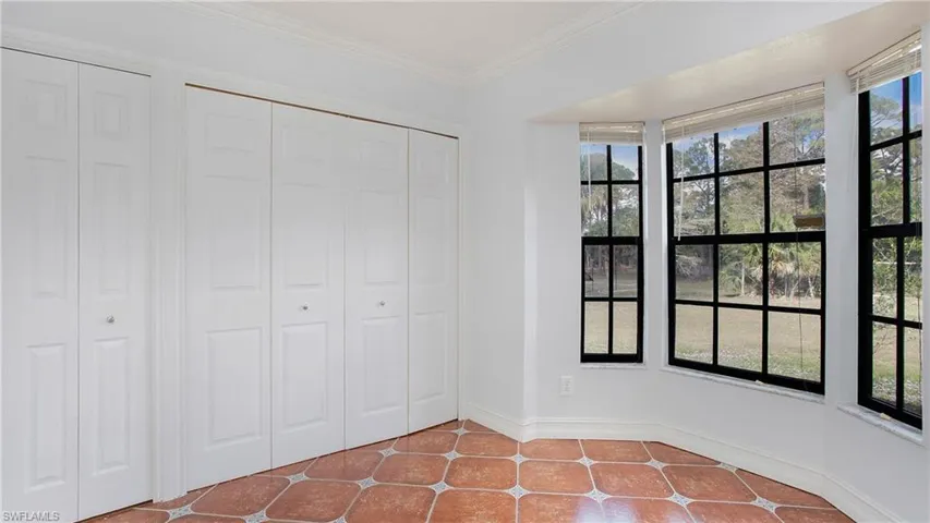 Breakfast nook looking out onto the back yard featuring patterned tile flooring and crown molding. Washer/dryer hook up in the closet
