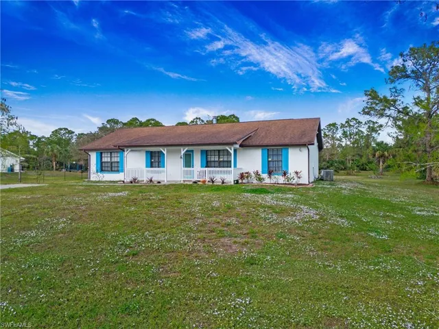 Ranch-style home featuring covered porch and front yard