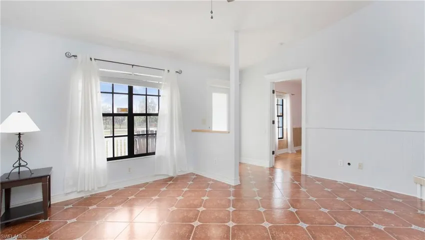 Living room featuring patterned tile flooring and vaulted ceiling