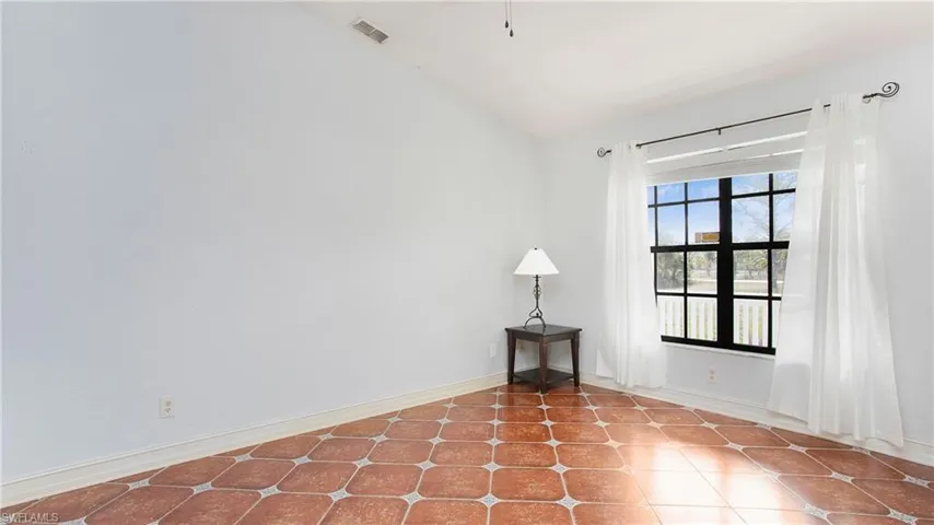 Living room featuring patterned tile flooring and vaulted ceiling