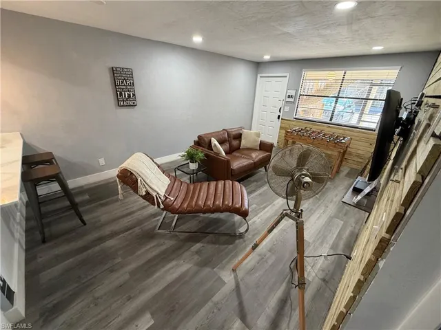 Living room with wood finished floors, recessed lighting, and a textured ceiling