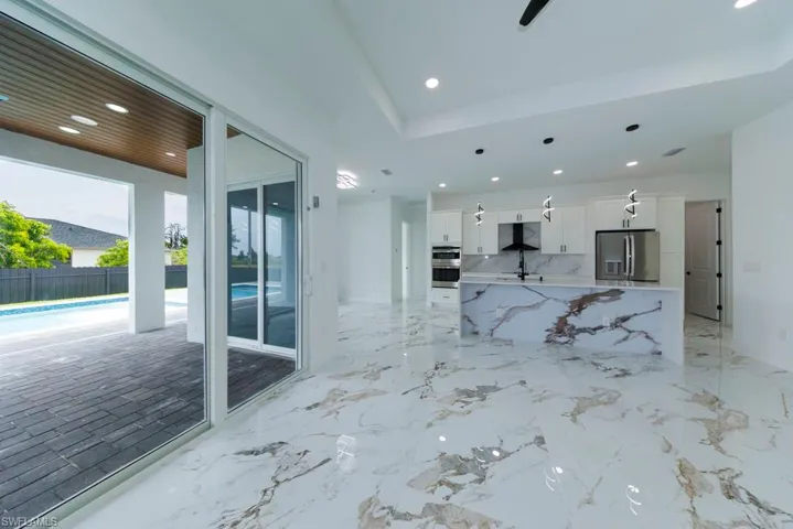 Unfurnished living room featuring recessed lighting and light marble finish flooring