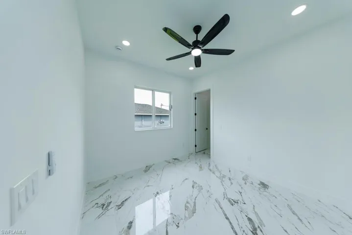 Spare room featuring marble finish flooring, recessed lighting, and ceiling fan