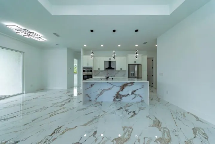 Unfurnished living room with light marble finish floors and recessed lighting